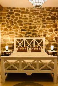 een bed in een kamer met een stenen muur bij Loft zona histórica Camino De Santiago in Tui