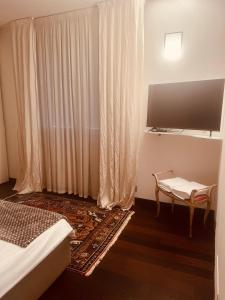 Dormitorio con TV, cama y mesa en Appartamento incantevole a piacenza, en Piacenza