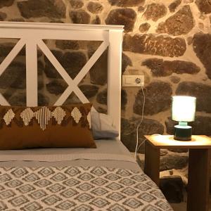 een slaapkamer met een bed en een stenen muur bij Loft zona histórica Camino De Santiago in Tui