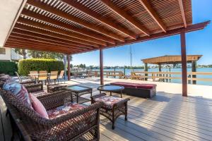 a patio with chairs and tables on a deck with the water at Amazing water front view home newly renovated 3BD 2BTH in Clearwater Beach