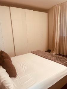 a bedroom with a bed with white sheets and a window at Appartamento incantevole a piacenza in Piacenza