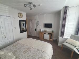 1 dormitorio con 1 cama y reloj en la pared en Tregarthen - Adult Only en Newquay