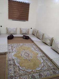 Sofá blanco en una sala de estar con alfombra en النسيم Nessim, en Nouakchott