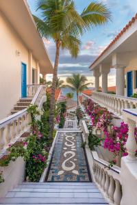 a resort balcony with flowers and a palm tree at Mar del Cabo By Velas Resorts in San José del Cabo