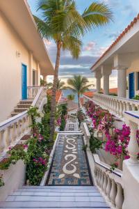 uma varanda de resort com flores e uma palmeira em Mar del Cabo By Velas Resorts em San José del Cabo