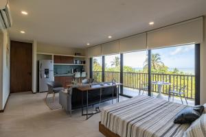 Cet appartement comprend une chambre avec un lit, une cuisine et un balcon. dans l'établissement Ocean View Loft - Punta Cocos, à Holbox