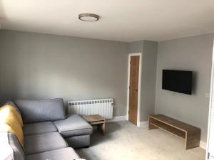 a living room with a couch and a tv at New ground floor 2 bed flat close to the beach in Southbourne