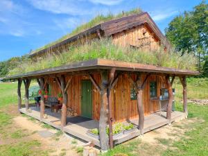 a cabin with a grass roof on top of it at CHALET BORŮVKA - biofarma na samotě v lesích in Pavlov