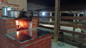 a brick oven with pots and pans on top at Pousada e camping Canastra Mineira in São Roque de Minas