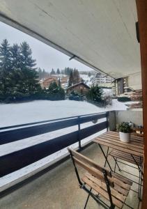 a balcony with a bench and a view of the snow at La Planchette - La Tzoumaz in Riddes