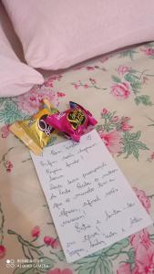 a piece of paper and a packet of candy on a bed at Pousada e camping Canastra Mineira in São Roque de Minas +49 photos