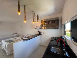 a small kitchen with a sink and a bed at Flat Por do Sol in Baía Formosa