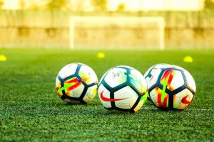 three soccer balls are sitting on a field at Holiday Inn St Louis - Creve Coeur in Saint Louis