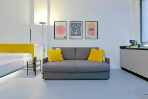 uma sala de estar com um sofá e uma cama em MONO Apartments em Bolonha