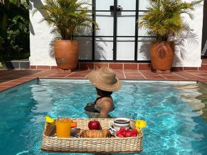 a person in a swimming pool with a tray of food at Casa Boutique Bellavista con piscina privada! in Melgar