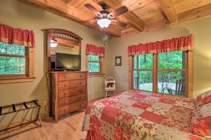 una camera con letto, TV e finestre di Woodland Cabin with Hot Tub and Deck 11 Mi to Boone! a Stony Fork