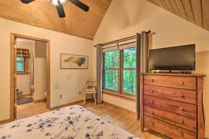 una camera con un letto e un comò con una televisione di Woodland Cabin with Hot Tub and Deck 11 Mi to Boone! a Stony Fork