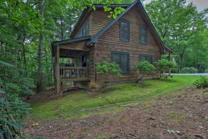 una casa in legno con veranda su un prato di Woodland Cabin with Hot Tub and Deck 11 Mi to Boone! a Stony Fork