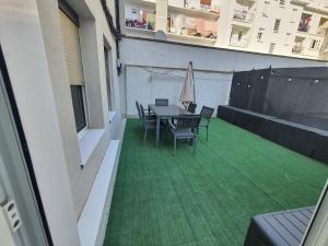 a balcony with a table and chairs on a green floor at Teo in Pamplona