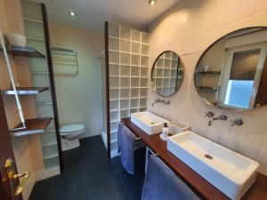 een badkamer met een wastafel, een toilet en een spiegel bij Teo in Pamplona