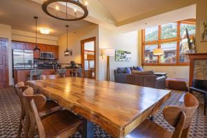 a dining room and living room with a large wooden table at The Village at Palisades Tahoe in Olympic Valley