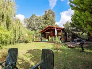 a yard with two chairs and a house at Lakeside Lodge Retreat in Tattershall