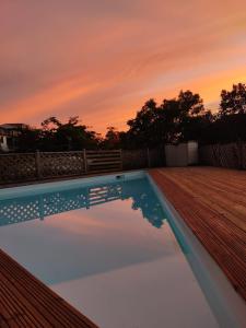 una piscina con puesta de sol en el fondo en logement accès piscine, en Basse-Terre