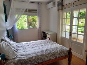 Cama en habitación con ventana y cama sidx sidx sidx sidx en logement accès piscine, en Basse-Terre