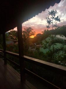 d'un balcon offrant une vue sur le coucher du soleil. dans l'établissement Casa Vermelha Búzios, à Búzios