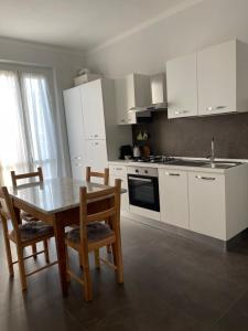 a kitchen with white cabinets and a table and chairs at Marchionis in Cremona