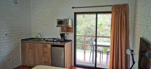 eine Küche mit einer Theke, einer Mikrowelle und einem Fenster in der Unterkunft Cálida suite en Liguiqui - Manta in Manta