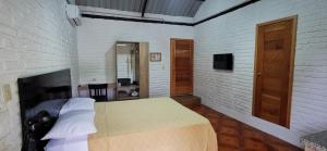 a bedroom with a bed and a brick wall at Cálida suite en Liguiqui - Manta in Manta