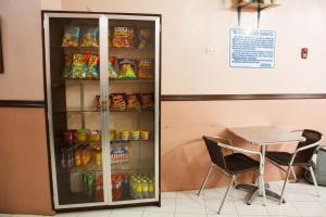 a refrigerator filled with food next to a table and chairs at GV Hotel - Naval in Biliran