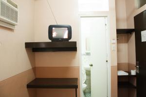 una televisione seduta su uno scaffale in una stanza di GV Hotel - Naval a Biliran