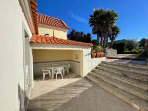 un patio con mesa y sillas junto a un edificio en Maison chaleureuse avec piscine et spa, en Vale de Cambra