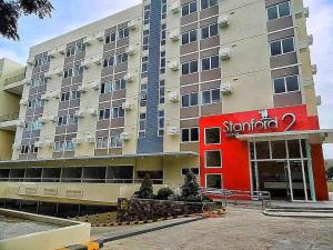 a hotel with a red sign on the front of it at Stanford Suites 2 Lilian in Silang