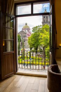 uma porta aberta para uma varanda com vista para um edifício em voco Royalty Puebla Downtown em Puebla