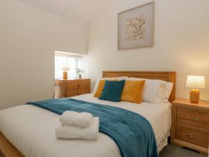 um quarto com uma cama grande e toalhas em The Cwtch em Abergavenny