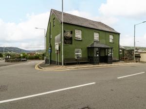 un bâtiment vert sur le côté d'une rue dans l'établissement The Cwtch, à Abergavenny