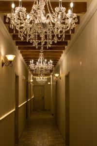 a hallway with a chandelier and a hallway with a door at Royalty Hotel Boutique Puebla in Puebla