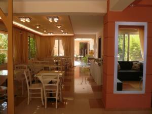 a dining room with tables and chairs and windows at Hotel Avra in Lygia