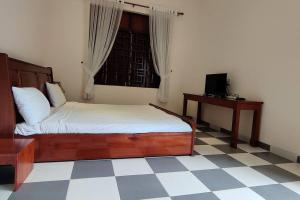 1 dormitorio con cama, escritorio y ventana en Banyan Villa Nha Trang en Nha Trang