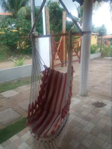 a hammock hanging from a pole in a yard at Casa na Praia de Saquaira - Península de Maraú. in Marau