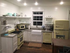 a kitchen with white cabinets and yellow appliances at Primrose Cottage - Private Lake, Hot Tub, ATV Trails in Mena