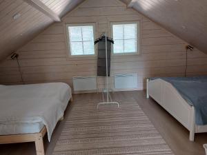 a bedroom with two beds and a tv in a attic at Villa Ruskamaja in Äkäslompolo