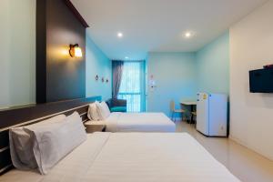 una camera d'albergo con due letti e una televisione di The Room at Maesai a Mae Sai