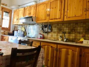 a kitchen with wooden cabinets and a kitchen table at THEO TRADITIONAL HOUSE in Eptalofos