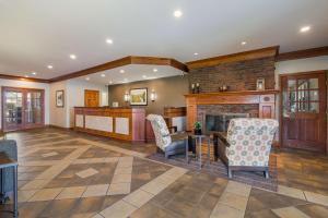 a living room with a fireplace and two chairs at Best Western University Inn in Canton