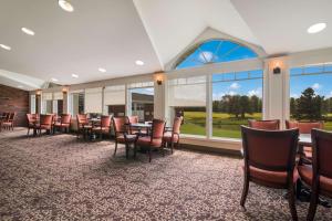 a dining room with tables and chairs and windows at Best Western University Inn in Canton
