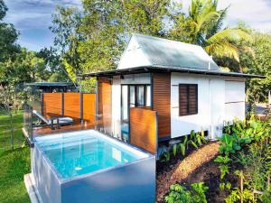 a small house with a swimming pool in front of it at Mercure Darwin Airport Resort in Darwin